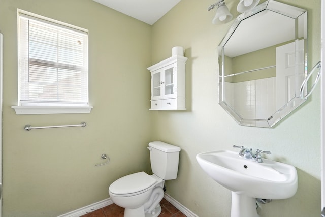 bathroom featuring a sink, baseboards, tile patterned flooring, and toilet