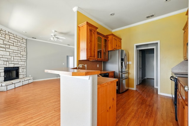 kitchen with visible vents, ornamental molding, glass insert cabinets, and black range with electric stovetop