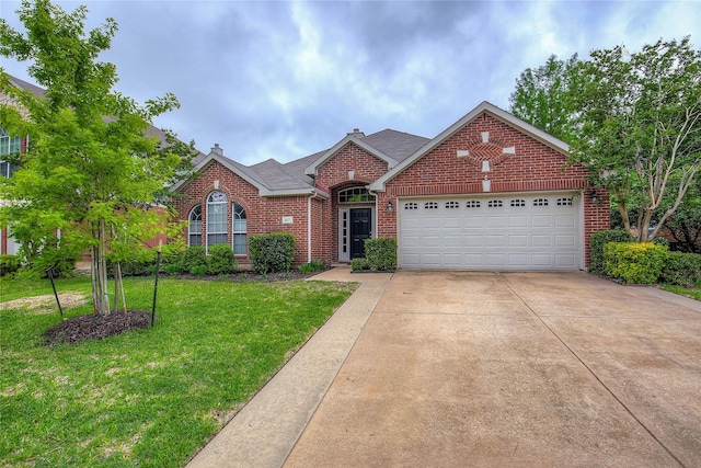 ranch-style home featuring a front yard, a chimney, brick siding, an attached garage, and driveway