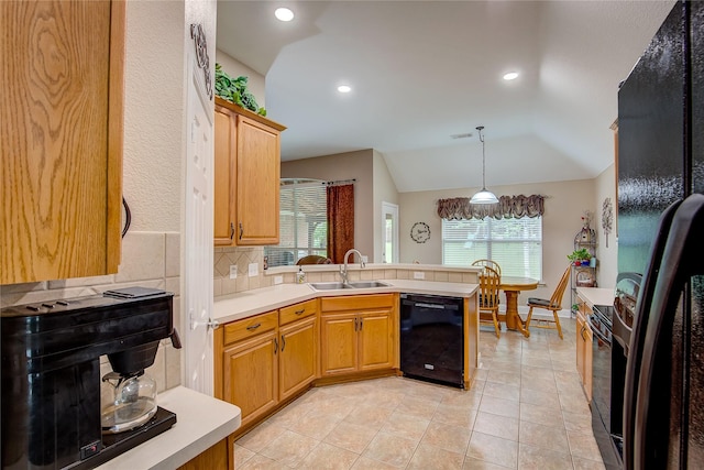 kitchen featuring a sink, light countertops, a peninsula, decorative backsplash, and black appliances