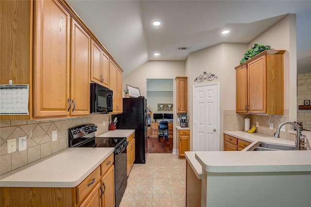 kitchen featuring visible vents, lofted ceiling, a sink, backsplash, and black appliances