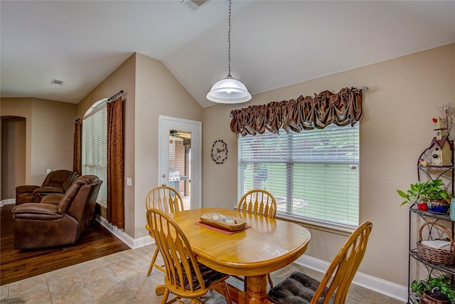 dining area featuring light tile patterned floors, baseboards, arched walkways, and visible vents