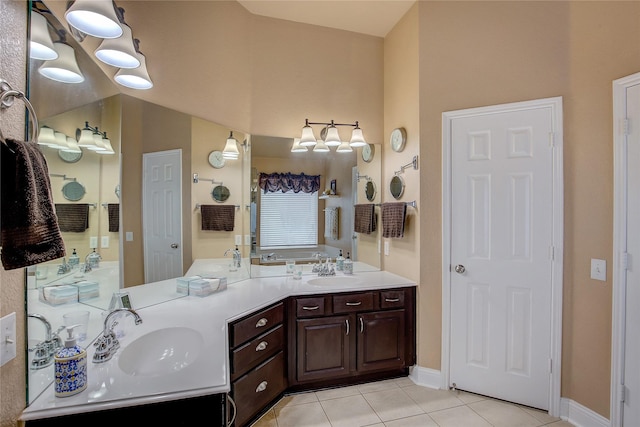 bathroom with a sink, tile patterned floors, baseboards, and double vanity