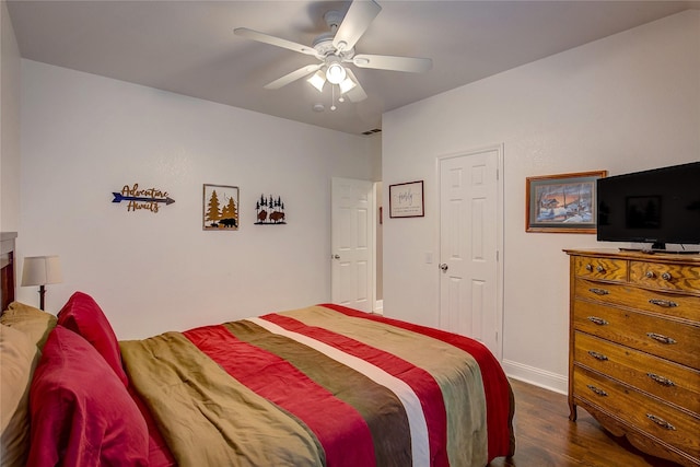 bedroom featuring baseboards, ceiling fan, and dark wood-type flooring