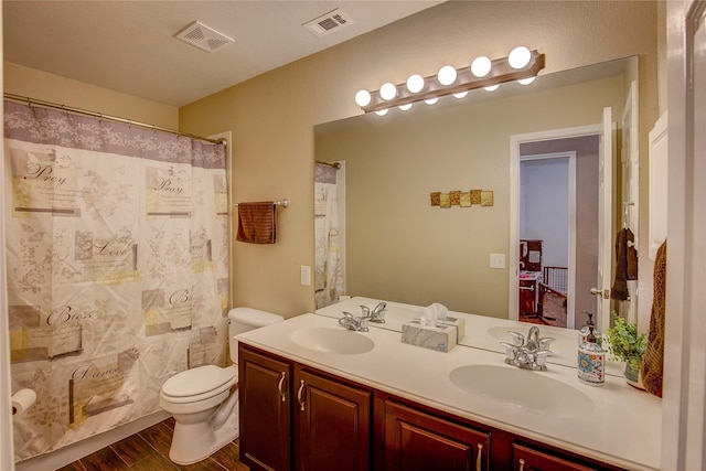 full bathroom featuring visible vents, a sink, wood finished floors, and toilet