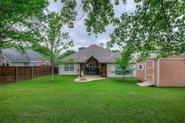 rear view of property with an outdoor structure, a storage shed, a fenced backyard, a lawn, and a patio