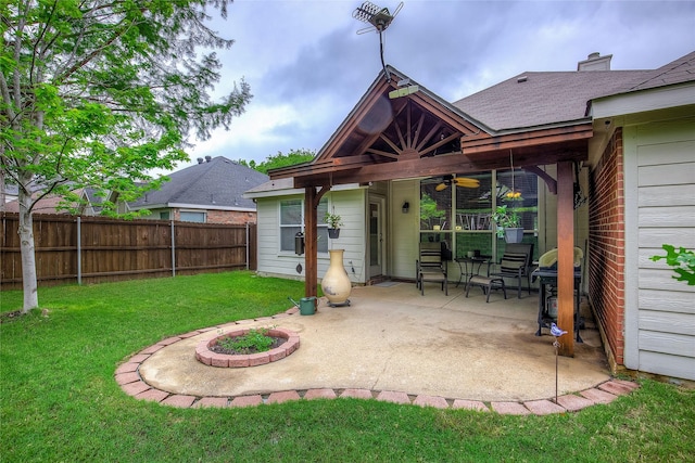 rear view of house featuring ceiling fan, a fire pit, a fenced backyard, a patio area, and a yard