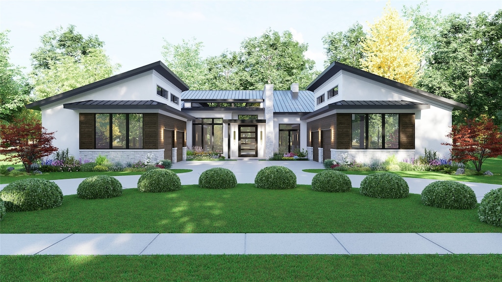 back of property with a standing seam roof, metal roof, a yard, and stucco siding