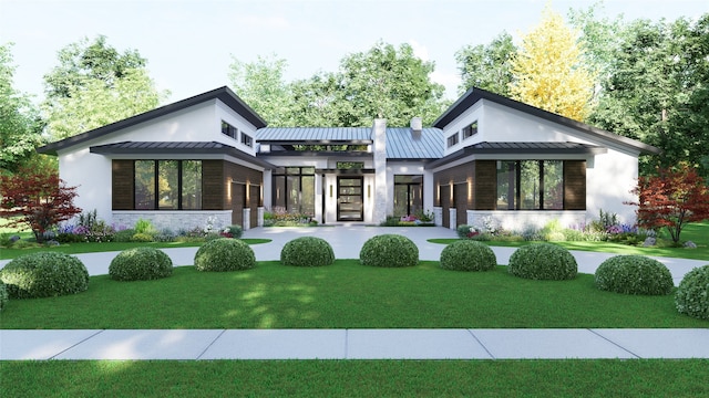 back of property with a standing seam roof, metal roof, a yard, and stucco siding