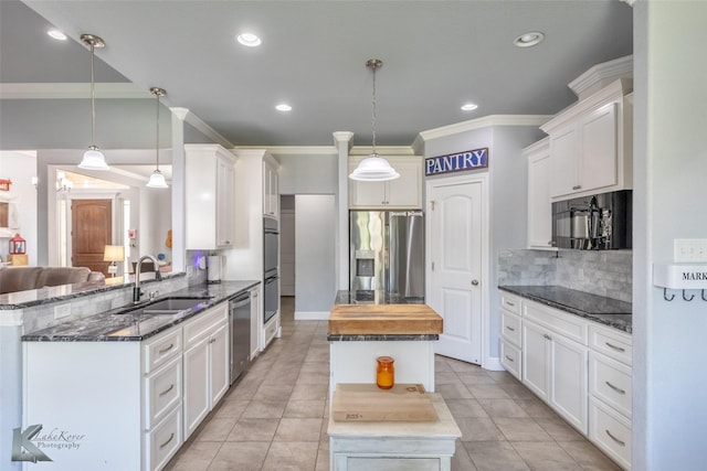 kitchen with crown molding, a center island, tasteful backsplash, a sink, and black appliances