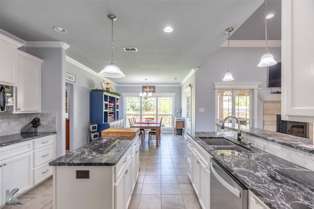 kitchen with stainless steel dishwasher, decorative backsplash, a sink, and a healthy amount of sunlight