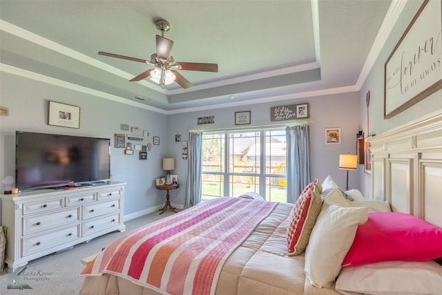 bedroom with crown molding, ceiling fan, a tray ceiling, and light colored carpet