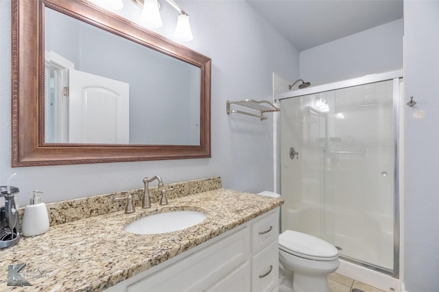 full bathroom featuring vanity, tile patterned floors, a stall shower, and toilet