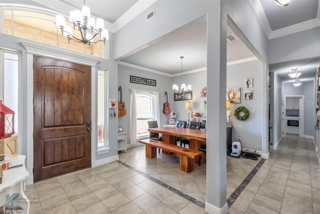 foyer entrance featuring crown molding, baseboards, an inviting chandelier, and visible vents