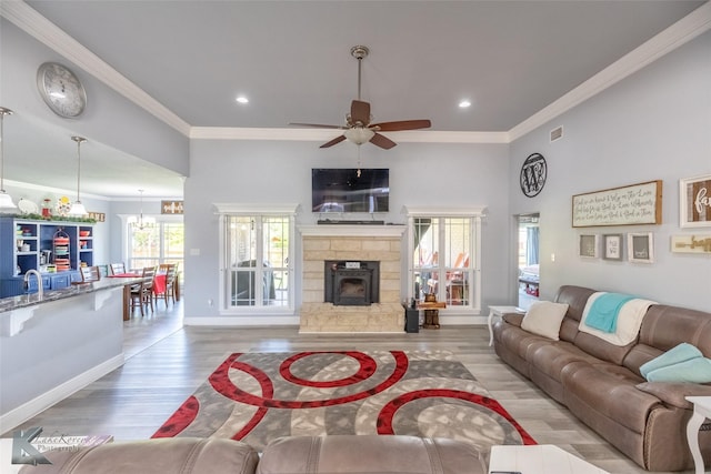 living room with a ceiling fan, visible vents, crown molding, light wood-type flooring, and recessed lighting