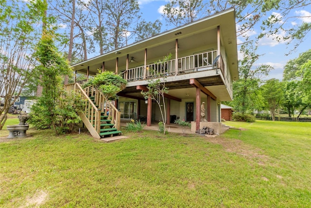 back of property featuring stairway, a deck, a patio, and a lawn