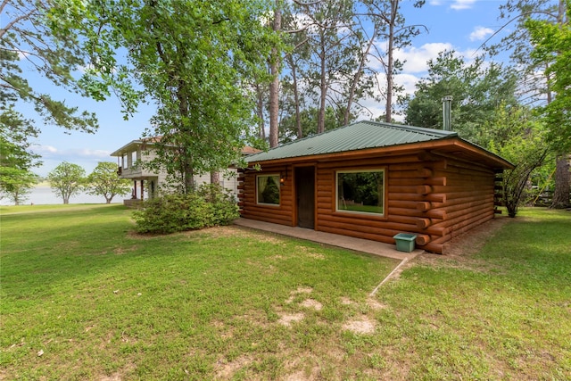 rear view of house featuring a lawn and log exterior