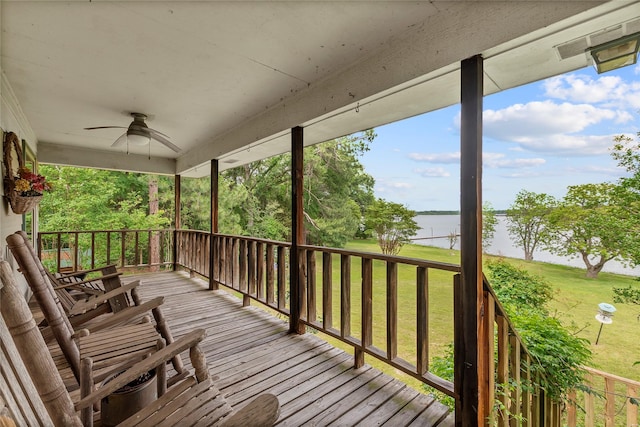 deck with a water view, a ceiling fan, and a yard