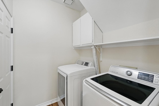 washroom with cabinet space, visible vents, and washer and clothes dryer