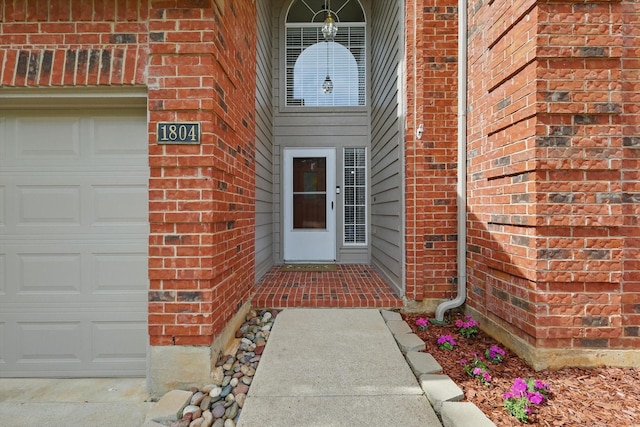 property entrance with brick siding and a garage