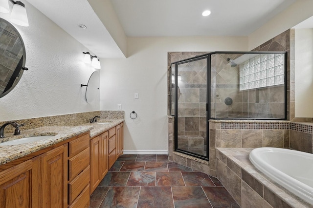 full bath with a sink, baseboards, a stall shower, and a bath