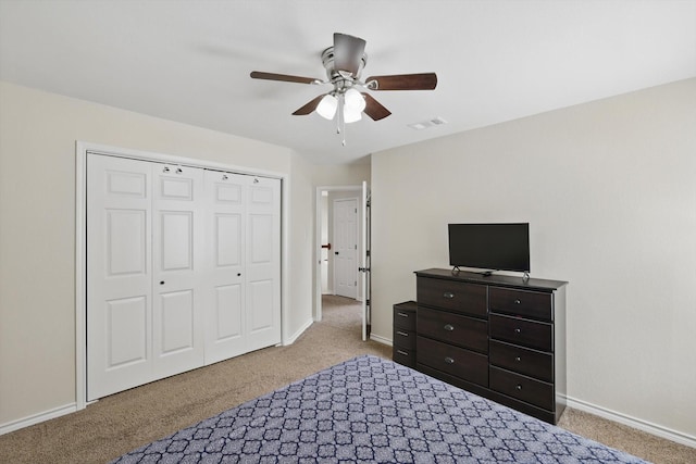carpeted bedroom with visible vents, a ceiling fan, baseboards, and a closet