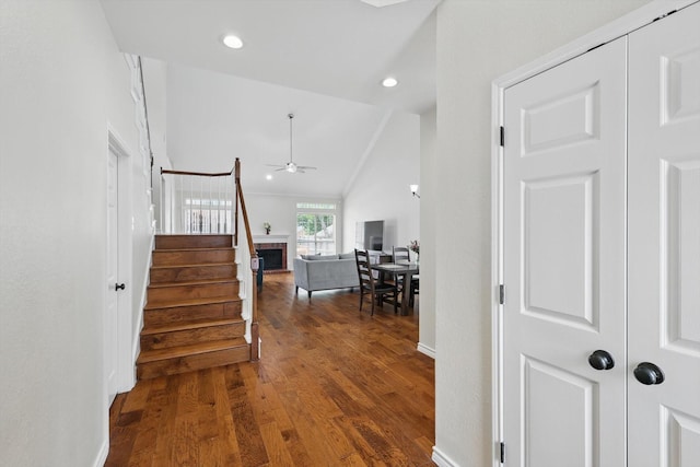 hallway featuring stairs, recessed lighting, wood finished floors, and lofted ceiling