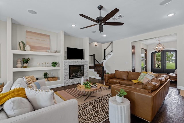 living area featuring stairs, visible vents, wood finished floors, and a fireplace