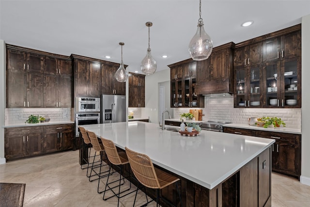 kitchen with a sink, appliances with stainless steel finishes, tasteful backsplash, and recessed lighting