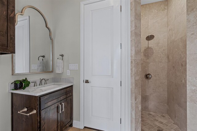 bathroom with vanity and a tile shower