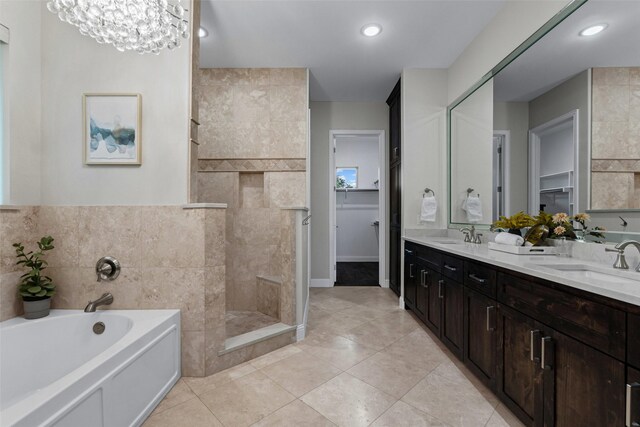 full bath with double vanity, a walk in shower, a sink, and a garden tub