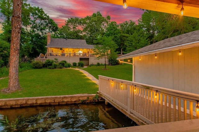 552 E Hideaway Ln, Hideaway, TX 75771 - back of house at dusk with a yard, a chimney, and a deck