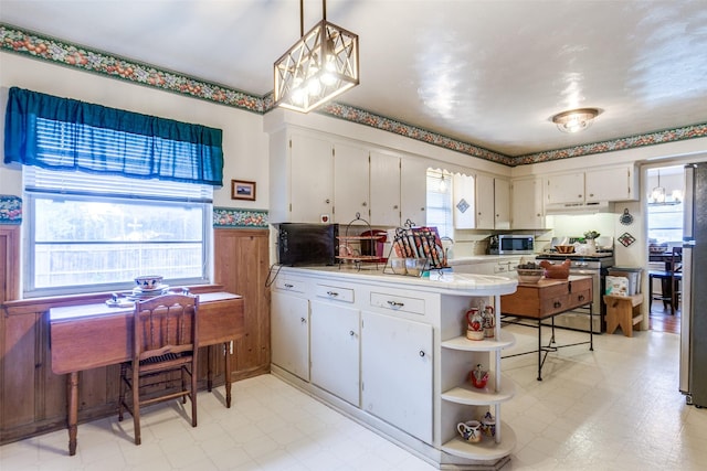 kitchen featuring open shelves, a peninsula, light floors, under cabinet range hood, and appliances with stainless steel finishes