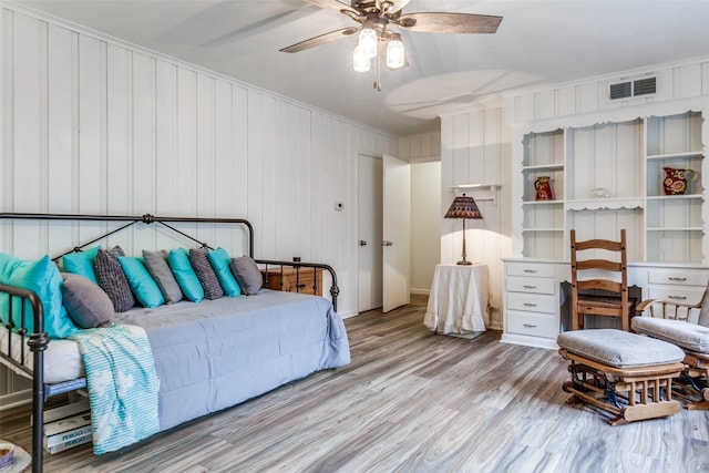 bedroom featuring visible vents, a ceiling fan, wood finished floors, and ornamental molding