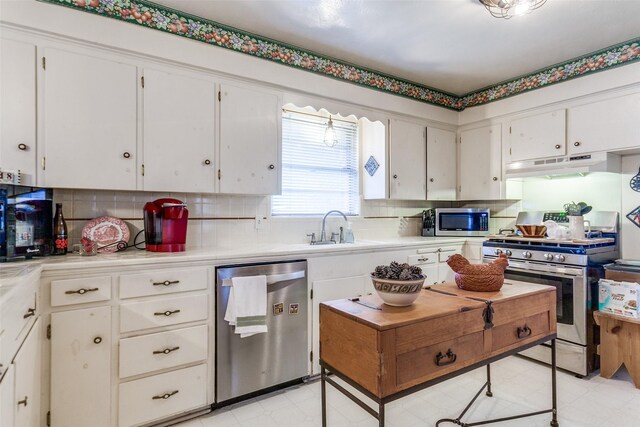 kitchen featuring backsplash, light countertops, under cabinet range hood, stainless steel appliances, and white cabinetry