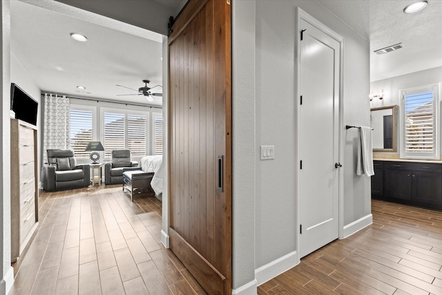 12225 Grosbeak Dr, Denton, TX 76207 - hallway featuring visible vents, wood finished floors, baseboards, recessed lighting, and a textured ceiling