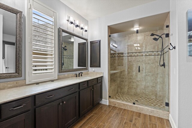 12225 Grosbeak Dr, Denton, TX 76207 - bathroom with wood finished floors, baseboards, a stall shower, and vanity