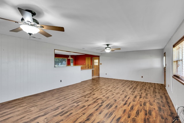 unfurnished living room featuring visible vents, a ceiling fan, wood finished floors, and a wealth of natural light