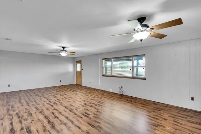 spare room featuring ceiling fan, wood finished floors, and visible vents