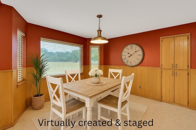 dining space with wainscoting and wooden walls