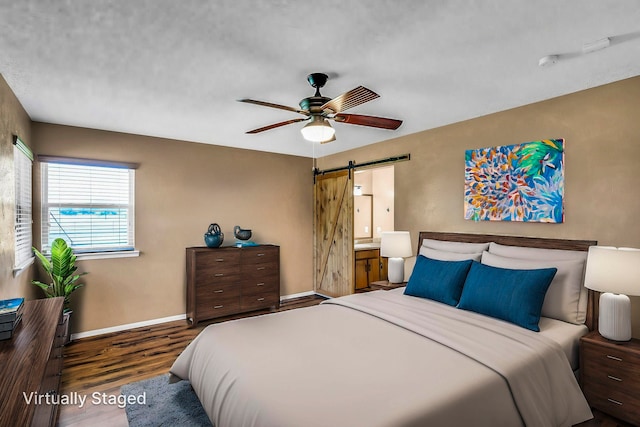 bedroom with baseboards, a barn door, a ceiling fan, and wood finished floors