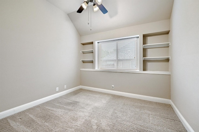 carpeted spare room featuring a ceiling fan, baseboards, and lofted ceiling