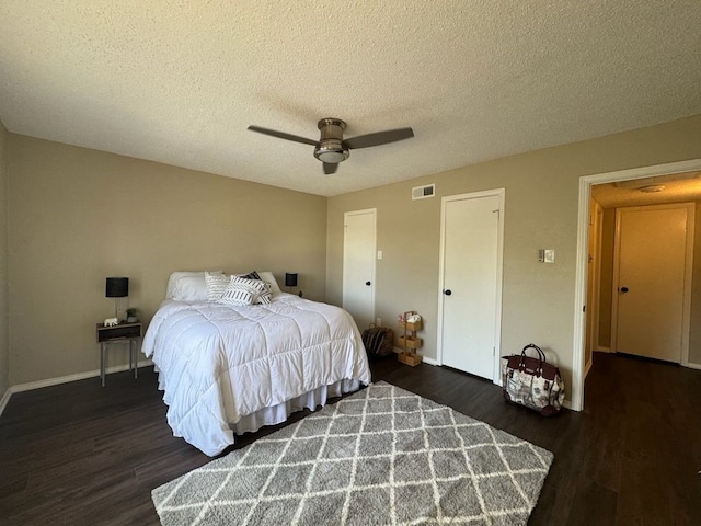 bedroom with visible vents, wood finished floors, baseboards, a textured ceiling, and a ceiling fan