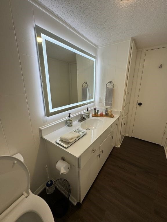 bathroom with vanity, a textured ceiling, wood finished floors, and toilet