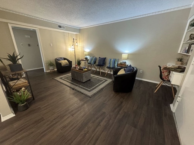 living room with visible vents, crown molding, wood finished floors, baseboards, and a textured ceiling