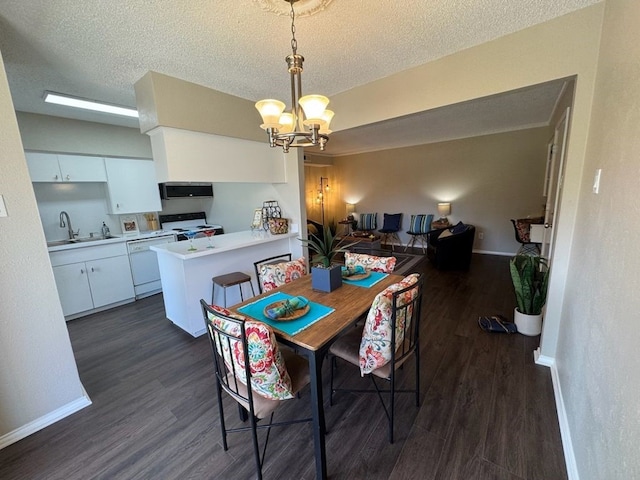 dining space featuring an inviting chandelier, a textured ceiling, dark wood finished floors, and baseboards