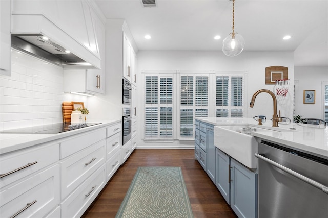 kitchen featuring stainless steel appliances, recessed lighting, a sink, and premium range hood