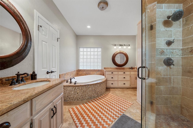 full bath featuring a sink, tile patterned floors, two vanities, a shower stall, and a garden tub