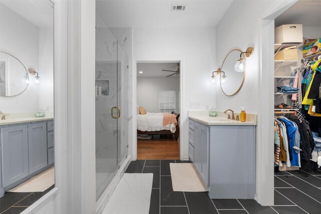 ensuite bathroom with visible vents, tile patterned flooring, a sink, a ceiling fan, and a marble finish shower