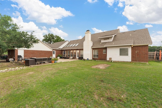 back of property with fence, a patio, an outdoor living space, brick siding, and a yard